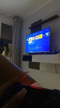 a flat screen tv sitting on top of a wooden shelf