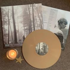 an image of a woman in the woods with a candle next to it and some photos