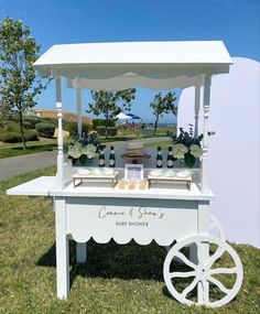 a white cart with flowers on it sitting in the grass