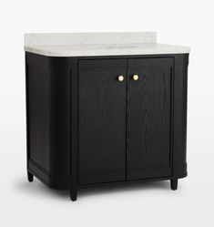 a black cabinet with white marble top and two brass knobs on the door handles