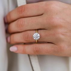 a woman's hand with a diamond ring on it