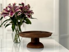 This Rustic Wood Vintage Cake Stand Vintage, Circa 1930, is the perfect addition to a rustic, primitive, or brutalist kitchen decor style.  Also great in Farmhouse or Cottage style Decor, this cake stand or pedestal's form is uneven around the rim, but it gives the piece an amazingly authentic and natural appeal. It also has a ribbed underside design, adding to the piece's creative detailing. Let this cake stand show off your next dessert! Dimensions: 13" x 13" x 5.5" Brutalist Kitchen, Rustic Wood Cake Stand, Wooden Cake Stand, Primitive Farmhouse Decor, Wood Cake Stand, Wood Cake, Cottage Style Decor, Wooden Cake, Primitive Farmhouse