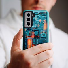 a man holding up a cell phone case with an electronic circuit board design on it