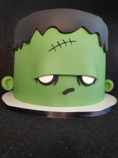 a close up of a cake with a zombie face on it's head and eyes