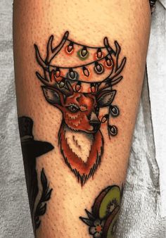 a close up of a person's leg with a tattoo on it and a deer wearing a crown