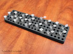 a black and white game board with lots of screws on it sitting on a wooden table