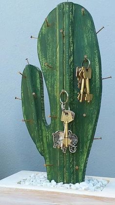 a cactus with two keys hanging from it's side and another keychain attached to it