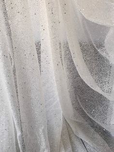 Glitter tulle. Off white tulle and translucent glitter. Overall effect is light ivory. Full glitter all over. Width is 140cm Price is for one meter Orders over one meter wll be in a continuous length White Tulle Evening Veil, White Tulle Veil For Evening, Glitter Sequin Tulle Fabric For Wedding, Wedding Sequin Tulle Fabric With Glitter, White Sheer Tulle Fabric For Party, White Glitter Tulle Fabric For Party, Sparkling Tulle Sequin Fabric For Prom, Elegant Glitter Tulle Fabric For Wedding, Glitter Tulle Fabric For Evening