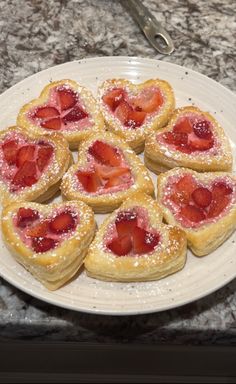 heart shaped pastries are arranged on a plate