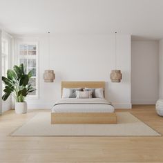 a bedroom with white walls and wood flooring has a large bed in the middle