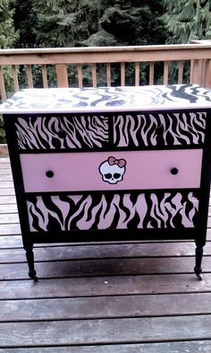 a pink and black zebra print dresser on a deck with trees in the back ground