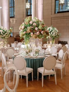 the tables are set with white chairs and green tablecloths for an elegant wedding reception