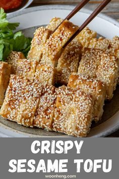 crispy sesame tofu on a plate with chopsticks