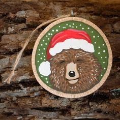 a wooden ornament with a bear wearing a santa hat