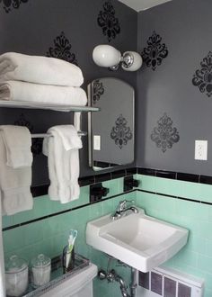 a white sink sitting under a bathroom mirror next to a towel dispenser