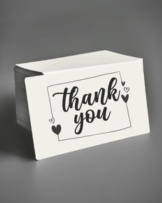 a thank card with the words thank you in black and white on it, next to an envelope