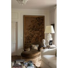 a living room filled with furniture and a chandelier hanging from the ceiling next to a painting