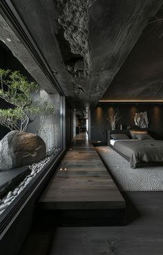 a large bed sitting next to a window in a room with rocks on the floor