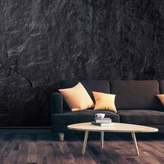 a living room with a couch, coffee table and black wall behind it in the corner