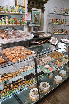 a bakery filled with lots of different types of doughnuts and pastries on display