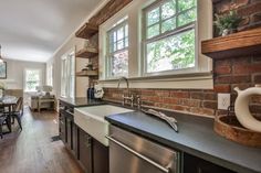 a kitchen with an oven, dishwasher, sink and dining room table in it