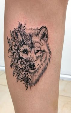 a black and white tattoo of a wolf with flowers on it's side thigh