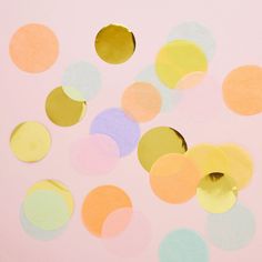 colorful confetti paper circles on a pink background