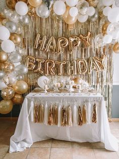 a birthday party with gold and white balloons