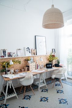 a room with two desks and pictures on the wall