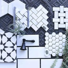 white and black tiles are laid out on the floor next to each other with plants