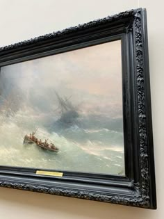 a painting hanging on the wall above a boat in rough seas with people rowing it