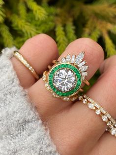 If you want old world charm with touches of deep green throughout the design - something fit for royalty - then you have found it in our Andora. We sourced a gorgeous 2.50ct brilliant round diamond for the center and sprinkled green emeralds that were custom cut to fit each and every nook and cranny of this beautiful halo ring. Approx Band Width (mm): 1.80mm Setting Diamond Quality (side stones): Colorless and VS clarity Approx Setting Total Carat Weight (side stones): 0.45 tcw Approx Production Artsy Rings, Halo Engagement Ring Emerald, Emerald Wedding Rings, Vintage Inspired Rings, Round Diamond Setting, Engagement Ring Shapes, Dear Future, Dope Jewelry, Gemstone Engagement