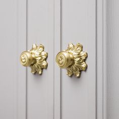 two gold knobs on the side of a white door