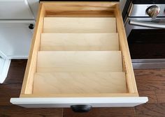 an open drawer in the middle of a kitchen