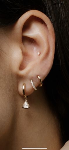 a close up of a person's ear with two different types of earrings on it