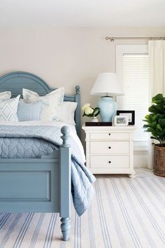 a bedroom with blue bedding and striped carpet