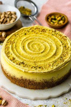 a cake with yellow frosting and nuts around it