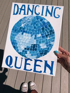 a person holding up a sign that says dancing queen