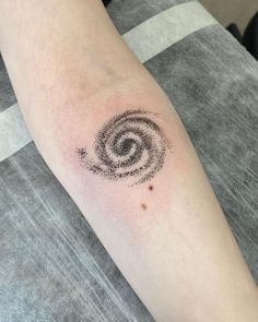 a person's arm with a tattoo on it that looks like a spiral design