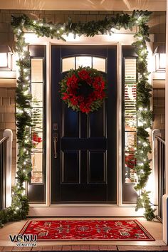 Traditional Christmas front door decor featuring a lush green wreath with red poinsettias, garlands wrapped in warm white lights, and a festive red doormat. Front Of House Christmas Decor, Fromt Door Garland, Red Garland Front Door, Front Door Garland Christmas Farmhouse, Red And White Front Door Garland, Front Porch Lanterns, Entry Door Decor, Cristmas Entry Door, Porch Lantern