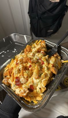 a tray with some food on it and a fork in the bowl next to it