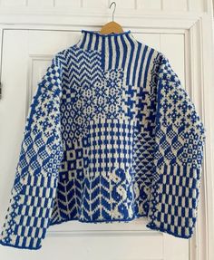 a blue and white sweater hanging on a door