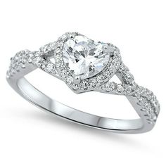 a white gold ring with a heart shaped diamond in the center and pave set shoulders