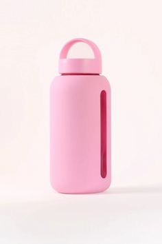 a pink water bottle sitting on top of a white table