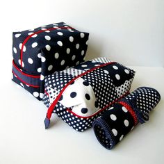 two black and white polka dot bags, one has a red ribbon around the edges