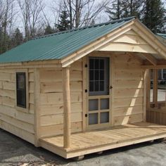 a small wooden cabin with a green roof