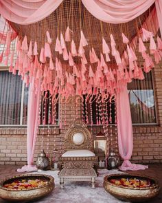 a decorated stage with pink drapes and tassels hanging from it's ceiling