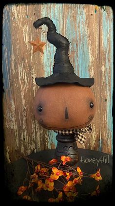 a small pumpkin with a witches hat on it's head sitting on top of a table