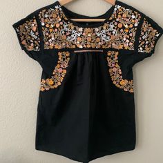 Nwot Black Top With Peach And White Embroidery! Never Worn. Smoke Free Home! 23” Long 17” Armpit To Armpit Orange Cotton Top With Floral Embroidery, Orange Short Sleeve Tops With Floral Embroidery, Orange Floral Embroidered Cotton Top, Orange Floral Embroidered Short Sleeve Tops, Orange Floral Embroidery Short Sleeve Tops, Embroidered Orange Cotton Top, Orange Embroidered Cotton Top, Fitted Embroidered Orange Tops, Fitted Orange Top With Floral Embroidery