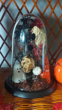 a glass cloche with halloween decorations under it